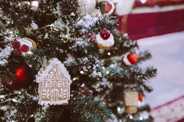 Kerstboom versierd met speelgoed in de vorm van een zoet dessert peperkoekhuis nieuwjaar 2022