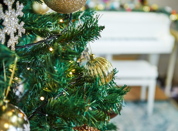 Kerstboom versierd met speelgoed. Tegen het oppervlak van een witte vleugel