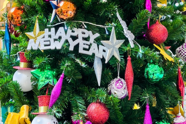 Kerstboom versierd met veelkleurige ballen en sneeuwpoppen met Happy new year borden en verlichting. Kerstboom versierd met veelkleurige ballen en sneeuwpoppen met Happy new year borden en verlichting.