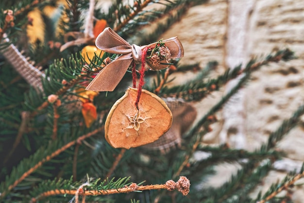 Kerstboom versieren met gedroogde stukjes appel met lint natuurlijke kerstornamenten voor de kerstboom zonder afval