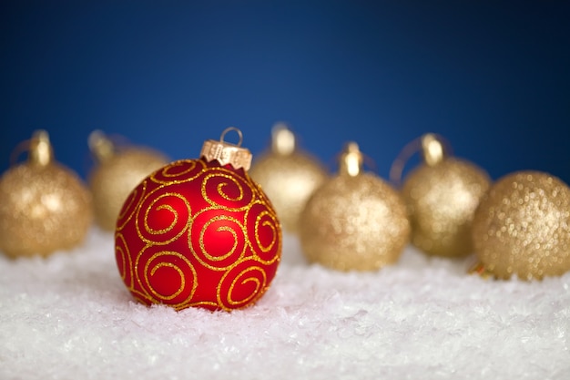 Kerstboomdecoratie in sneeuw op blauwe achtergrond