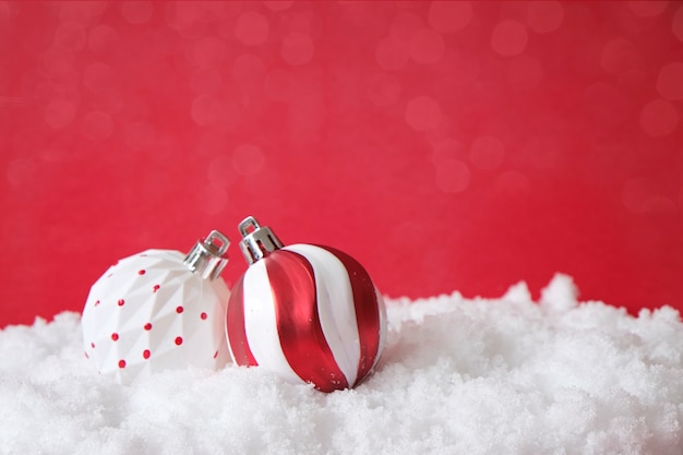 Foto kerstboomdecoratie, witte en rode ballen, op sneeuw. kerstkaart, bespotten