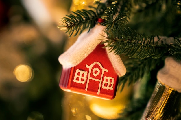 Kerstboomspeelgoed in de vorm van een huis op tak Kerststemming achtergrond Vakantiesfeer Cousing verhuur concept makelaarsdiensten hypotheek aankoop lening Hypotheek kopen onroerend goed