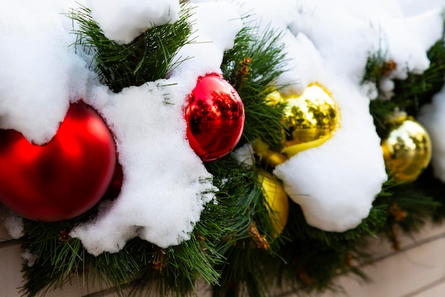 Kerstboomspeelgoed op dennentakken in de sneeuw Het concept van Nieuwjaar en Kerstmis