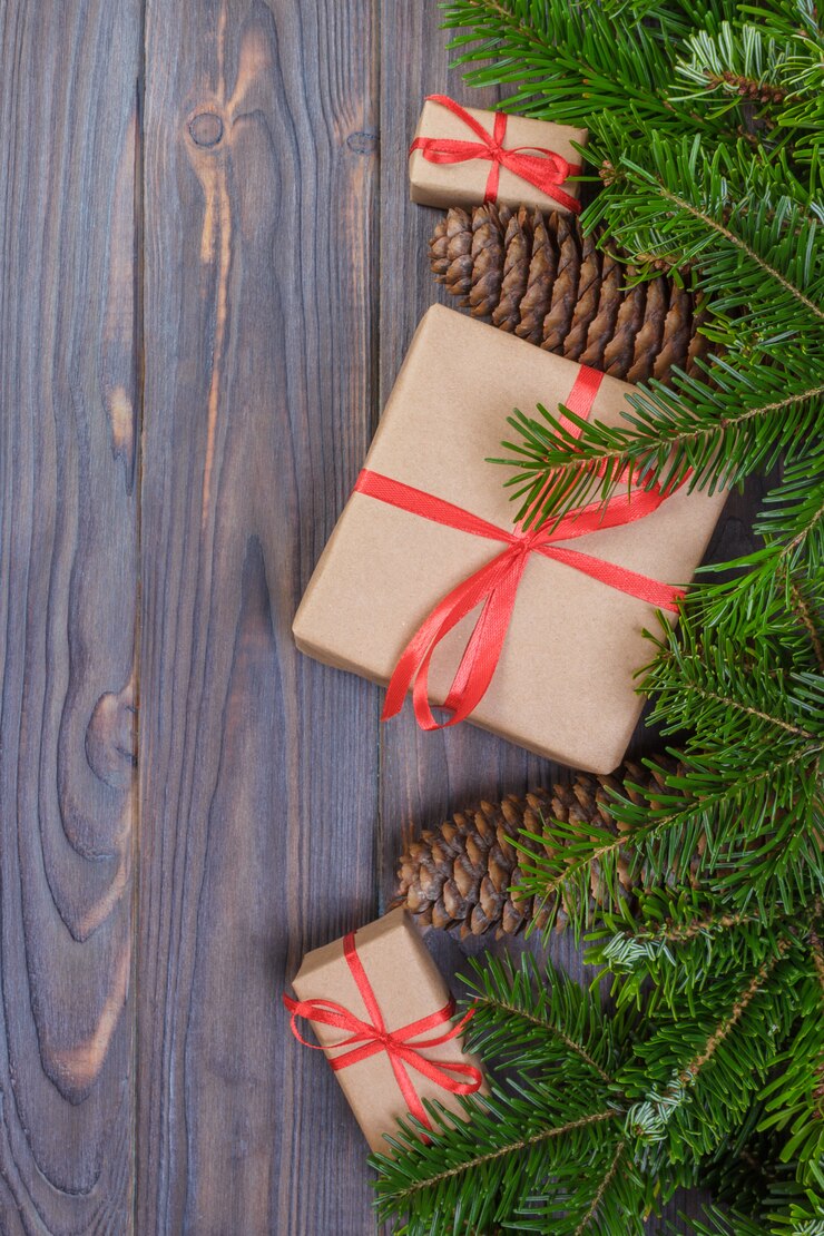 Kerstboomtak, decoratie en giftvakje op witte houten lijst