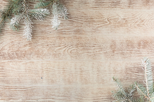 Kerstboomtak met dennenappels op rustieke houten tafel. Winter achtergrond met kopie ruimte. Bovenaanzicht. plat leggen