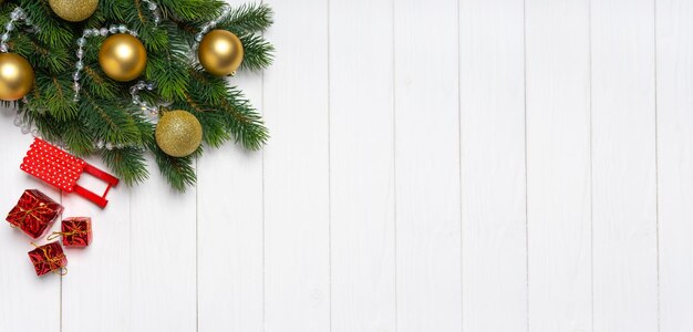 Kerstboomtak versierd met gouden ballen en decor op witte achtergrond