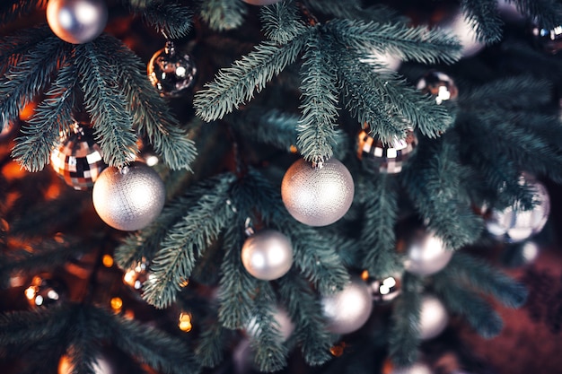 Kerstboomtakken en hangend speelgoed in warme kleuren erop