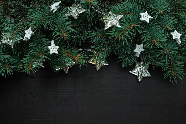 Kerstboomtakken met New Year's decor en sterren op een donkere houten