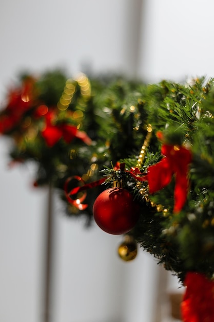 Foto kerstboomtakken met versieringen en rode bal in de kamer