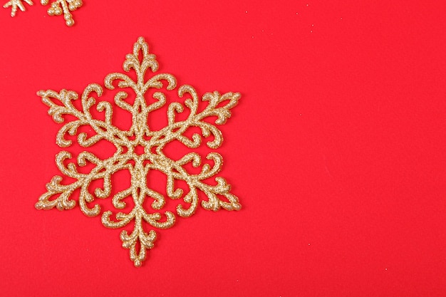 Kerstboomversieringen in de vorm van gouden sterren op een rode close-up als achtergrond