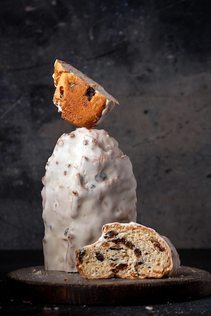 Kerstbrood stollen met noten en gedroogde vruchten op een houten plank die voedsel donkere foto in evenwicht houdt