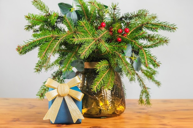 Kerstcadeau en boeket van dennentakken in interieur kerststilleven