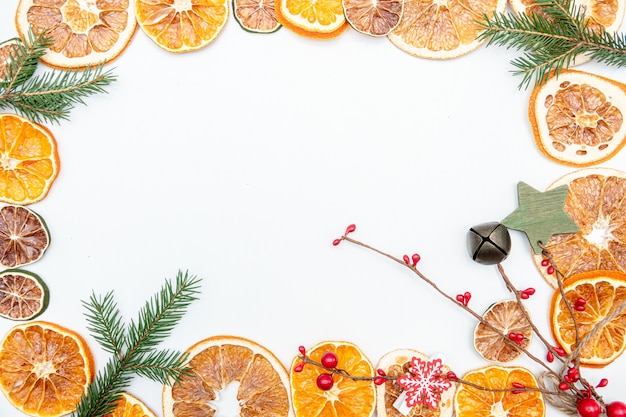 Kerstcadeau met gedroogde oranje gouden en rode ballen boog geïsoleerd op een witte achtergrond