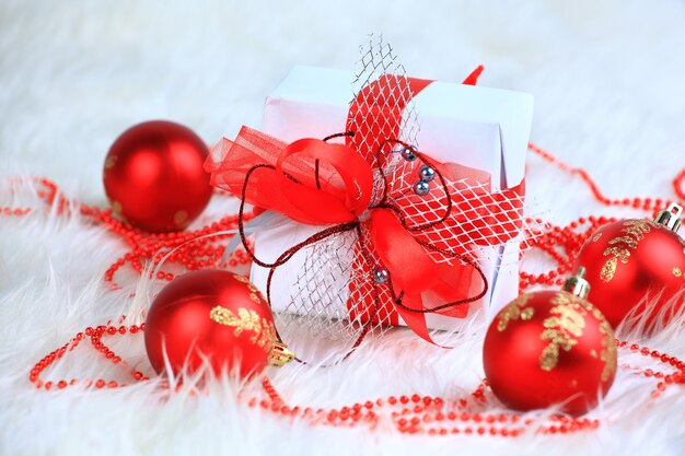 Kerstcadeau met rode ballen geïsoleerd op een witte achtergrond