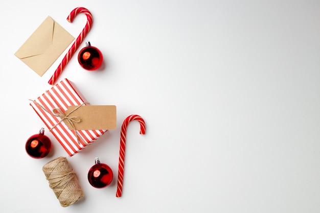 Kerstcadeau met zuurstokken en kerstballen op witte achtergrond bovenaanzicht