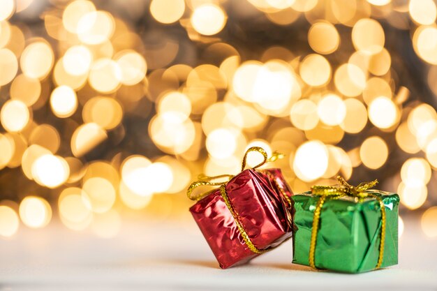 Kerstcadeau rode en zilveren kerstballen tegen bokeh lichten gouden glanzende glitter achtergrond met kopieerruimte