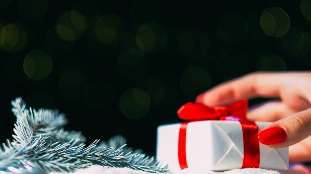 Foto kerstcadeau vakantie verrassing groet felicitatie vrouw hand zetten cadeau doos met rode tape