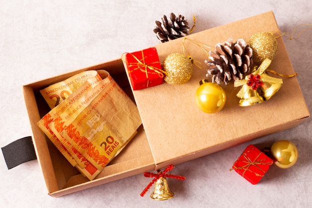 Kerstcadeaus in ambachtelijk papier op grijs met decoraties.