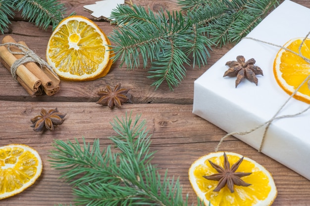 Kerstcadeaus of geschenkdoos verpakt in kraftpapier met versieringen dennenappels droog oranje