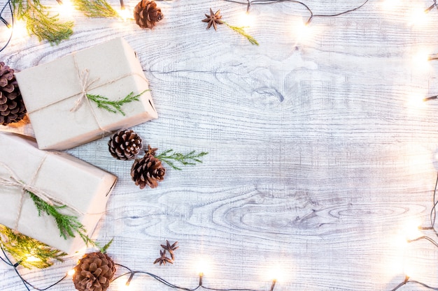 Kerstcadeaus op een witte houten achtergrond met dennen en dennenappels