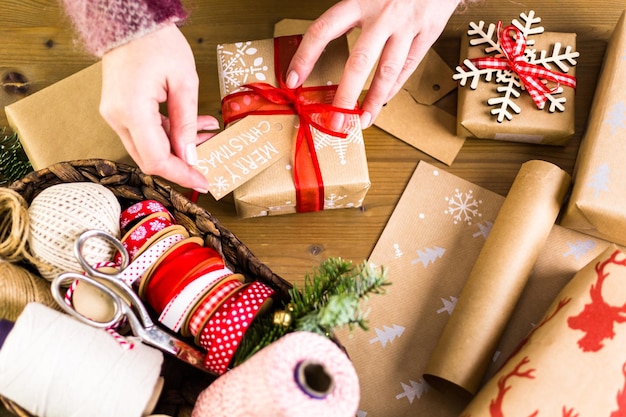 Kerstcadeaus verpakt in bruin papier met rode linten.