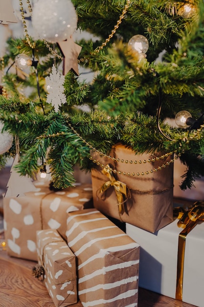 Kerstcadeaus verpakt in kraftpapier onder de kerstboom.