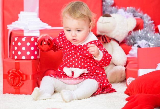 Kerstcadeaus voor peuters Dingen om te doen met peuters met kerst Klein babymeisje speelt in de buurt van stapel geschenkdozen Gezinsvakantie Cadeaus voor kinderen eerste kerst Kerstactiviteiten voor peuters