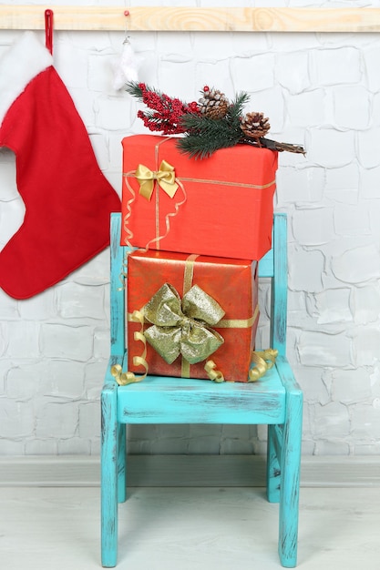 Kerstcadeautjes op blauwe stoel op bakstenen muurachtergrond