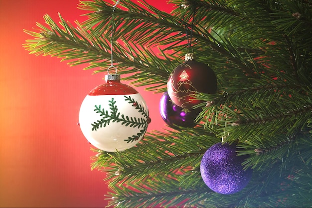 Kerstcompositie Ballen op een kerstboom close-up op een rode achtergrond