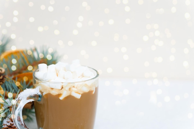 Kerstcompositie cacaoglas glas met marshmallow zijslingers sneeuwspar takken