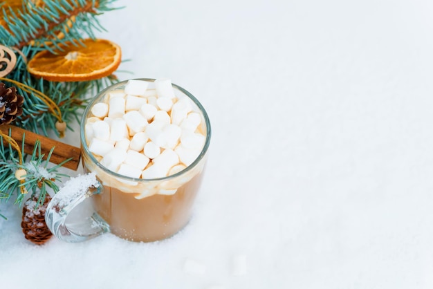 Kerstcompositie cacaoglas glas met marshmallow zijslingers sneeuwspar takken