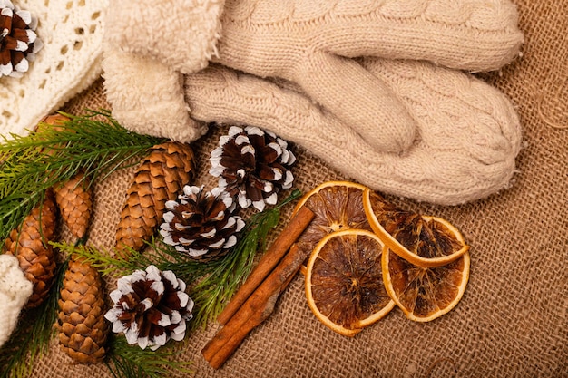 Kerstcompositie Kerstkegels handschoenen kaneel sinaasappelen op burlap