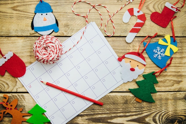 Kerstcompositie met een zweefvliegtuig of kalender Plat vilt handgemaakt speelgoed Rode wanten vilt Santa rendieren kerstboom op een houten achtergrond Het concept van Kerstmis en Nieuwjaar