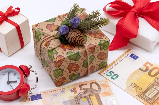 Kerstcompositie met geschenkdozen 50 euro en een wekker Flat Lay