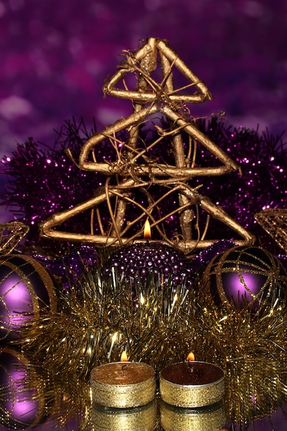 Kerstcompositie met kaarsen en decoraties in paarse en gouden kleuren op lichte achtergrond