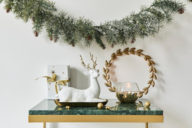 Foto kerstcompositie met prachtige decoratie, kerstboom en krans, herten, geschenken en accessoires in modern interieur. sjabloon.