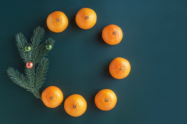 Kerstcompositie op een groene achtergrond. Kerstboom met speelgoed en verse mandarijnen.