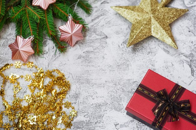 Kerstcompositie van sparrengroene takken, nieuwjaarsslinger, cadeau, ster en kerstspeelgoed