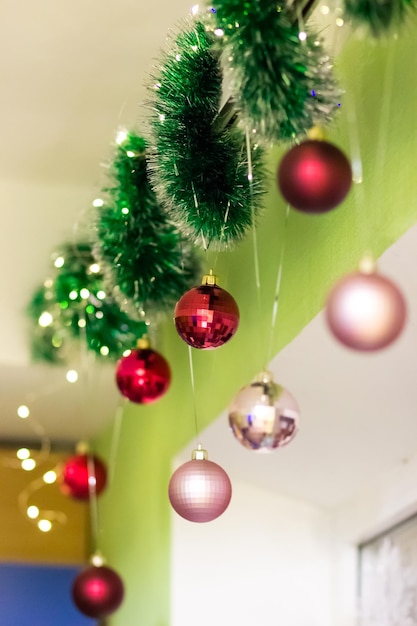 Kerstdecor boven het raam Groene slinger en ballen van rode en roze kleur