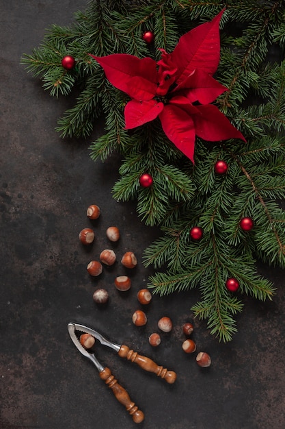 Kerstdecor met dennentakken, poinsettia, hazelnoten en notenkraker