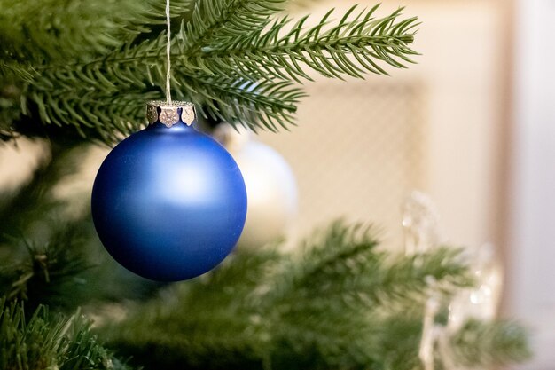 Kerstdecoratie blauwe bal hangt aan pijnboomtakken kerstboom slinger huisdecoratie cop