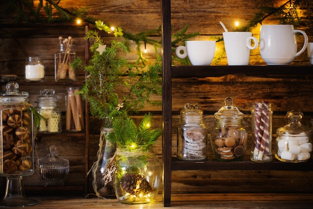 Kerstdecoratie cacaobar met koekjes en snoep op oude houten achtergrond in natuurlijke rustieke stijl