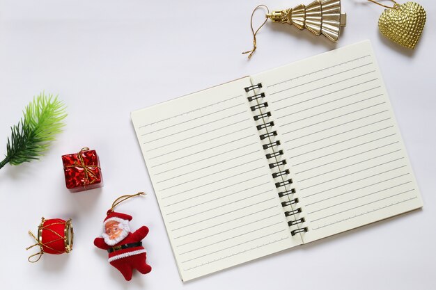 Kerstdecoratie en lege notebook op witte achtergrond.