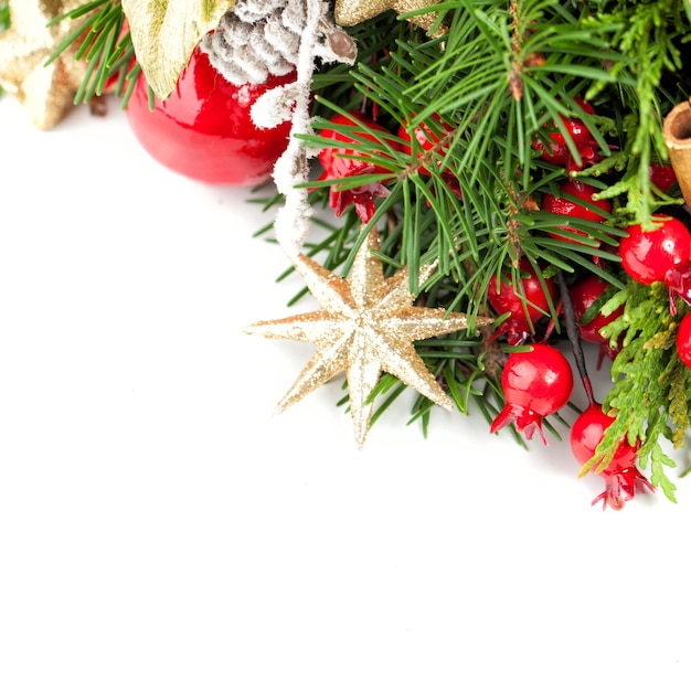 Kerstdecoratie, kerstboom takje, gouden ster, kerstballen en rode bessen op witte achtergrond