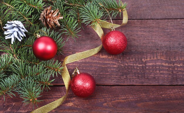 Kerstdecoratie met mooie kleurrijke ballen, kerstboom, kegels en linten op houten