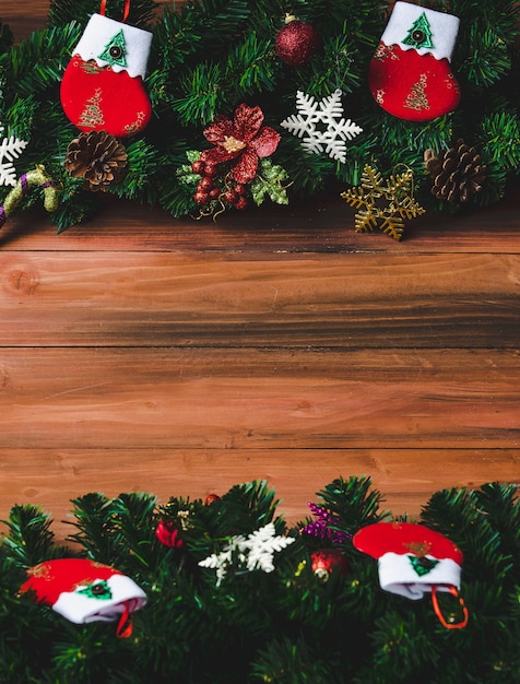 Kerstdecoratie op houten achtergrond met kopieerruimte, pijnboomtakken, kerstsokken en verschillende soorten ornamenten rekwisieten genomen van hoog boven de kijkhoek.