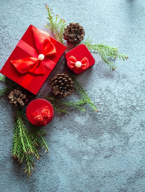 Kerstdecoratie samenstelling op grijze betonnen achtergrond met een mooie rode geschenkdoos
