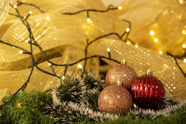 Kerstdecoratieballen met kerstverlichting en gele achtergrond