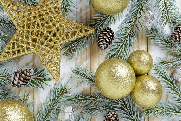 Kerstdecoraties, gouden kleurenballen en sterren op een witte houten tafel. Bovenaanzicht, kopie ruimte.